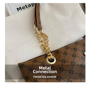 Detail of the brown monogram tote with golden metal chain strap and leather handle