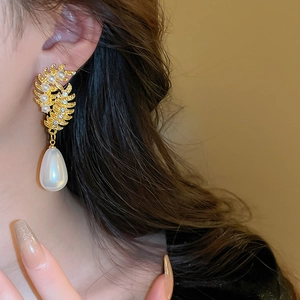 Detail of vintage wheat ear earrings with pearls and crystals on a model wearer