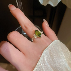 Close-up of 14K gold plated ring featuring marquise-cut emerald and white diamonds