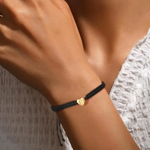 Minimalist black nylon braided heart bracelet with gold letter B charm on a model's wrist
