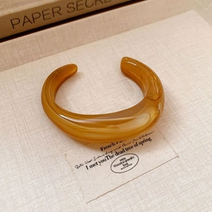 Chunky amber acrylic C-shaped open cuff bracelet with a glossy retro finish