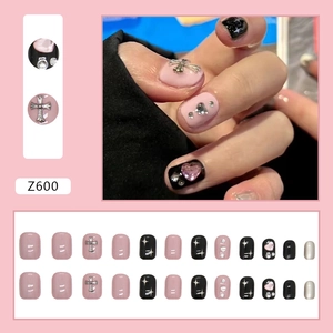French blush press-on nails set with pink hearts, black crosses, and 24 square-oval tips