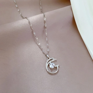 Detailed view of silver dolphin necklace with sparkling zircon stone on champagne silk background