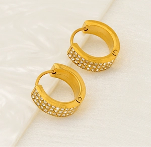 Macro shot of gold hoop earrings with three rows of sparkling micro-paved zircons