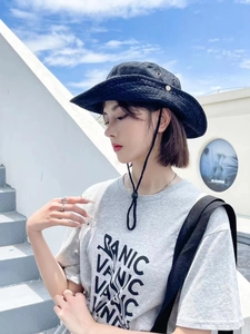 Détail du chapeau de soleil en denim noir avec évents métalliques et cordon réglable