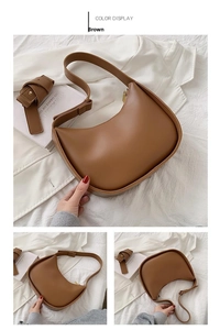 Vue détaillée du sac besace en cuir mat marron avec bandoulière réglable et lignes fluides