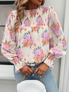 Detail of floral chiffon blouse featuring a smocked high neck and elegant puff sleeves