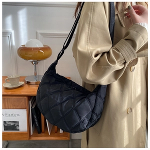 Close-up of black quilted hobo bag with large lattice stitching and satin finish