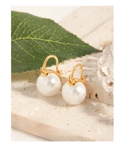 Detailed close-up of elegant round white shell pearls with a polished gold finish