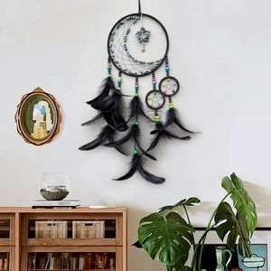 Large black dream catcher with crescent moon and stars hanging in a cozy room setting