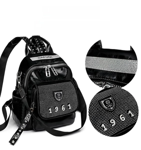 Close-up of black rhinestone backpack featuring silver studs and shield logo detail