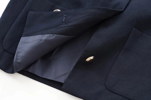 Detail of navy jacket with gold buttons and high-density twill fabric texture