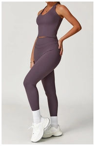 Detailed side view of criss-cross back yoga vest and high-waist plum leggings