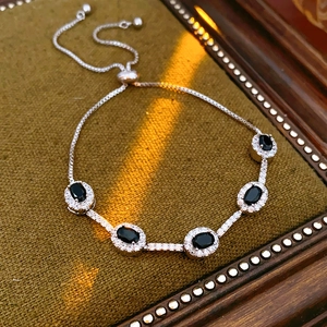 Makroaufnahme von verstellbarem Zirkon-Armband mit schwarzen Edelsteinen auf grünem Samt