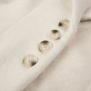 Detailed macro view of four marble texture buttons on soft plush faux fur sleeve cuff