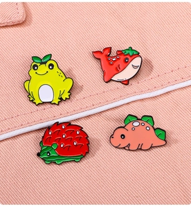 Close-up of cute cartoon frog, whale, hedgehog and dinosaur enamel pins on fabric