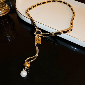 Y-shaped gold necklace with black weave, OT buckle, square letter tag and pearl pendant