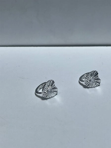 Macro detail of S925 sterling silver heart earrings with sparkling central zircon