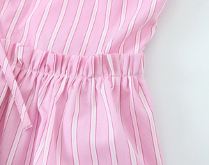 Close-up of pink striped poplin shorts featuring elastic pleated waistband and fine stitching