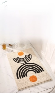 Close-up of plush geometric bath mat with orange dots and modern Nordic arched patterns
