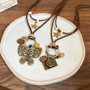 Detail of vintage wax cord necklace featuring butterfly pendant and wooden beads