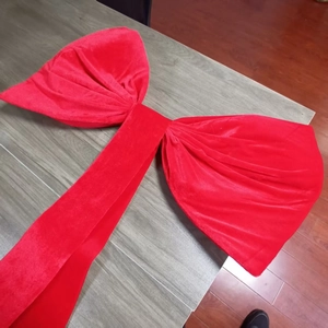 Detail of red large velvet decorative bow with long ribbons for wedding party background