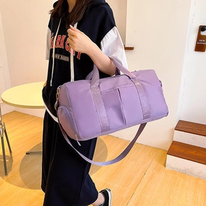Dettaglio borsa a secchiello intrecciata viola con tracolla regolabile e ampia capacità
