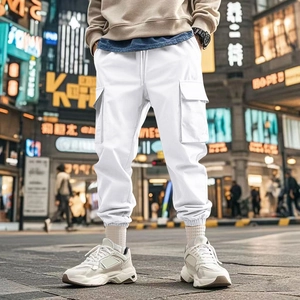 Detail of white cargo pants with large flap side pockets and elastic ankle cuffs