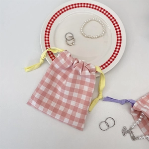 Detail of pink plaid drawstring pouch with yellow rope for jewelry and cosmetics