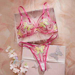 Detailed view of pink lace bra set with green butterfly embroidery in a premium gift box