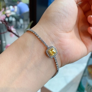 Silver tennis bracelet featuring a square yellow cushion cut zircon and clear stones