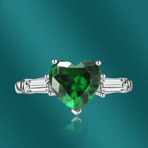 Macro shot of a luxury heart-shaped green zircon ring with sparkling baguette diamonds