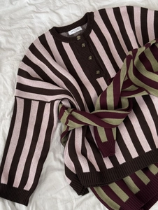 Detailed close-up of brown and pink striped knit sweater with half-button collar detail