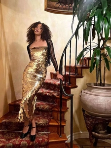 Detail of gold sequin tube dress with a black lace bolero on a glamorous evening gown