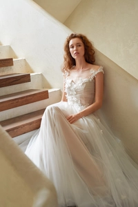 Détail d'appliques florales sur robe de mariée en tulle à col en V avec jupe à couches
