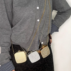Detailed shot of mini rhinestone crossbody bags in gold and silver with metal chain straps