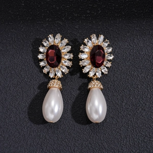 Détail de boucles d'oreilles vintage avec strass rubis et perles en forme de larme