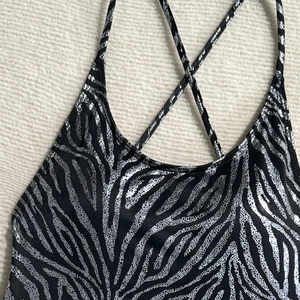 Detail of metallic zebra print swimsuit featuring cross-back straps and shimmering finish