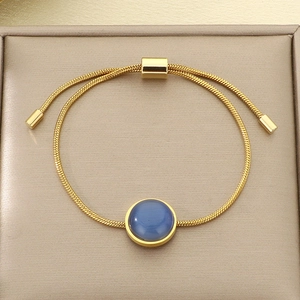 Détail d'un bracelet ajustable en chaîne serpent dorée avec pierre œil de chat