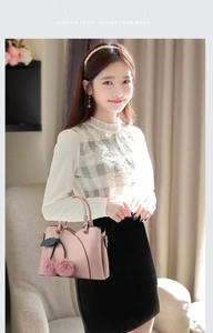 Detail of pink fashion handbag with plush pompom charms and soft leather texture