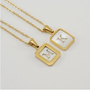 Détail des pendentifs carrés en nacre sur acier inoxydable 18K avec les lettres M et K