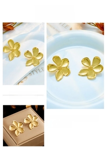 Detailed view of irregular golden flower earrings with matte texture and petal details