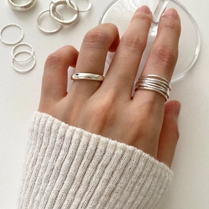 Detail of 925 sterling silver multi-layer geometric rings on model's hand