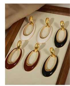 Detailed view of hollow oval enamel earrings in white, black and wine red with gold trim