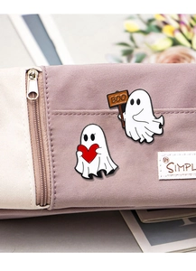 Detail of Halloween ghost enamel pins with heart and BOO sign on purple pouch