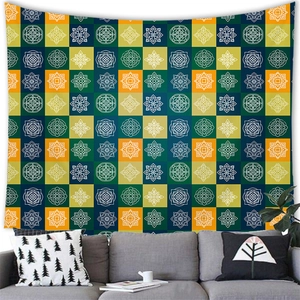 Detail of colorful bohemian mandala patterns on a wall tapestry above a grey sofa