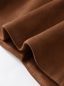 Gros plan sur la texture en daim marron foncé avec bordure à double surpiqûre