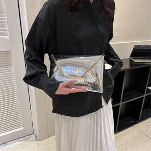 Silver crocodile embossed envelope clutch bag shown in a stylish minimalist setting