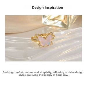 Close-up of golden butterfly ring with pink opal wings and sparkling zircon accents