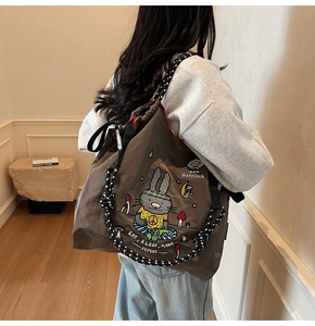 Detail of canvas tote bag featuring cute rabbit embroidery and thick rope shoulder straps
